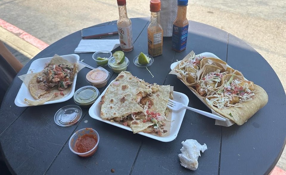 Printed menu with tacos, seafood, and small plates.