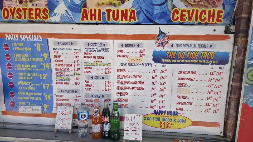 Menu board showing grilled fish and octopus dishes.